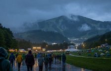 비 내리는 산악 음악축제에서 우비를 입은 관객들이 이동하는 모습